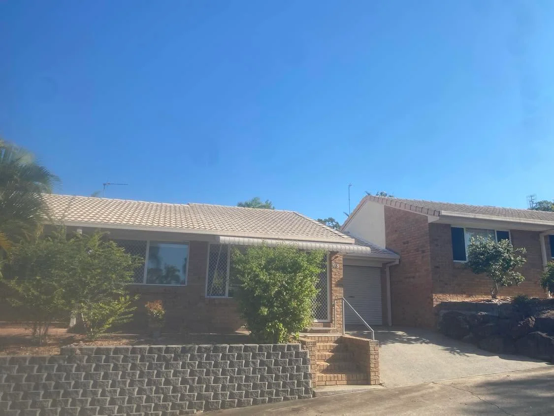 Brick house exterior with overgrown garden before maintenance, Molendinar